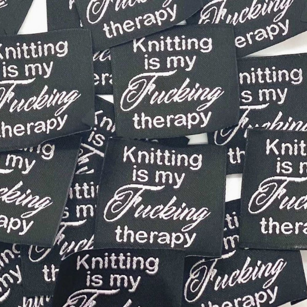 Vævet etiket "Knitting is my Fucking therapy"...
