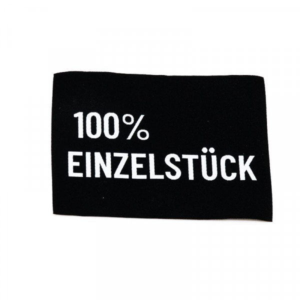 Vævet etiket "100% Einzelstück" 38 x 58 mm